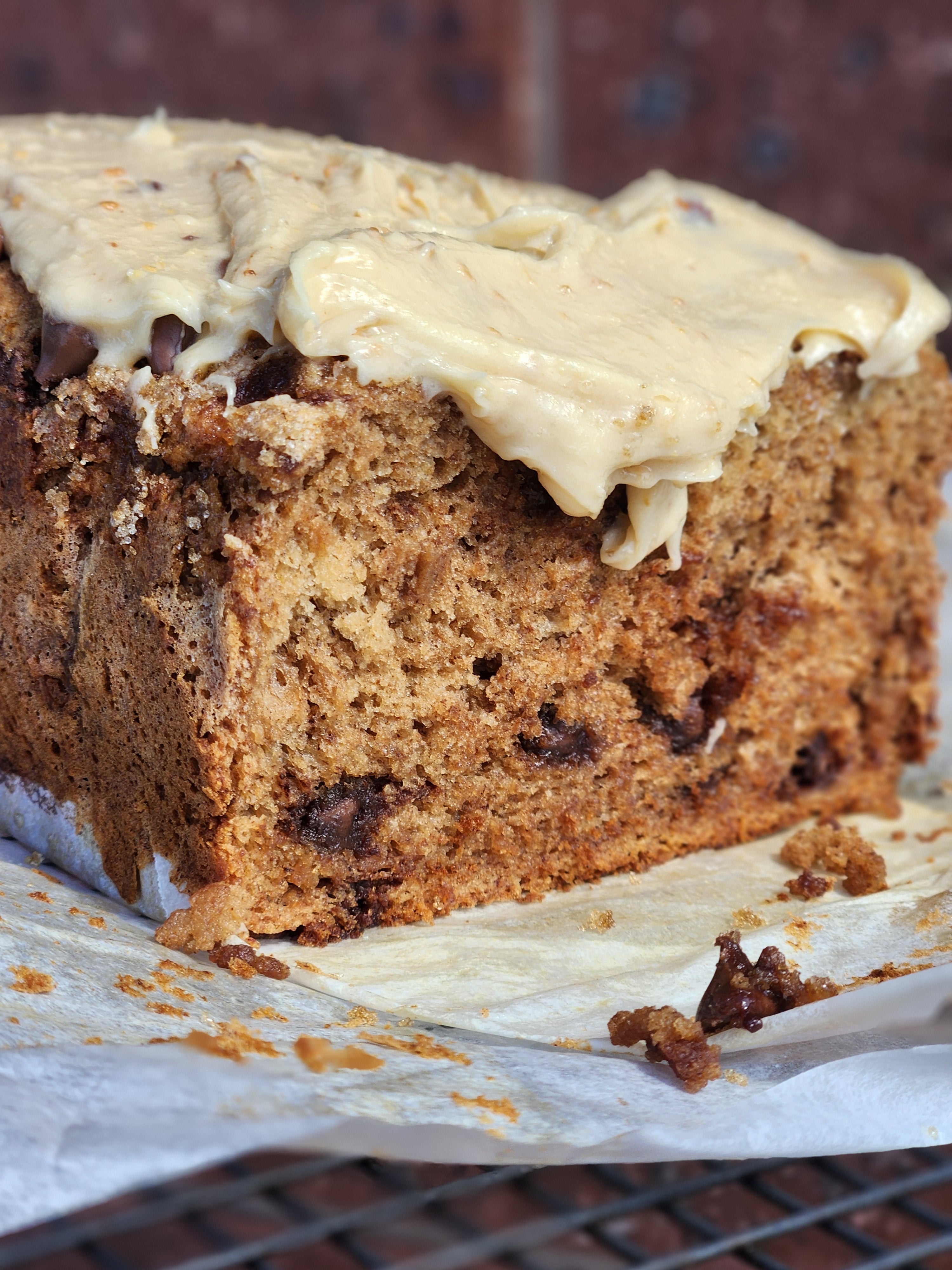 a close up of a moist gluten free banana bread topped with a creamy icing